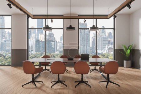 Foto de Elegante interior de la conferencia con sillas y mesa con ordenador portátil, piso de madera. Espacio para conferencias con planta, ventana panorámica de los rascacielos de Bangkok. Renderizado 3D - Imagen libre de derechos