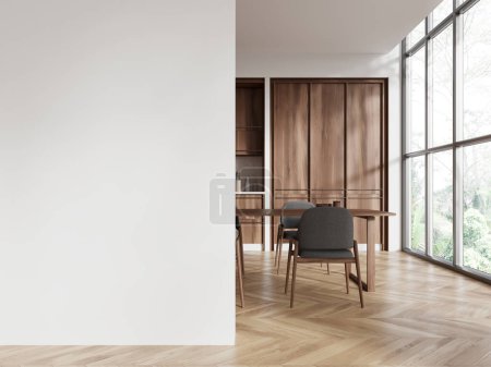 Foto de Elegante interior de la cocina del hogar con mesa de comedor y sillas, piso de madera. Comedor con armario de cocina, ventana panorámica y burla de partición de pared. Renderizado 3D - Imagen libre de derechos