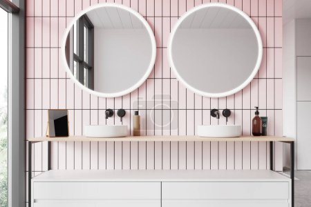 Téléchargez les photos : Élégant intérieur de salle de bain avec double lavabo, vanité blanche avec accessoires et deux miroirs ronds sur le mur de tuiles roses. Fenêtre panoramique sur les tropiques. rendu 3D - en image libre de droit