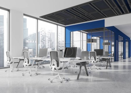 Foto de Esquina de elegante oficina de espacio abierto con paredes azules y blancas, piso de hormigón y fila de mesas de ordenador con sillas grises. renderizado 3d - Imagen libre de derechos