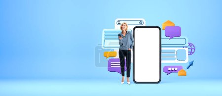 Photo for Happy smiling woman standing near mock up smartphone, web bar search and speech bubbles with mail. Concept of e-mail, website and online communication - Royalty Free Image
