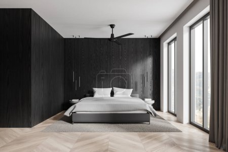 Foto de Elegante cama interior del dormitorio del hotel, mesita de noche en la alfombra, piso de madera. Dormitorio moderno con diseño de madera negra y ventana panorámica al campo. Renderizado 3D - Imagen libre de derechos