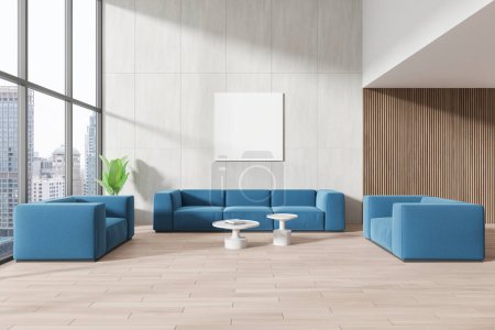 Foto de Interior de la moderna sala de estar con paredes blancas, suelo de madera, tres cómodos sofás azules de pie cerca de la mesa de café y plaza mock up cartel. renderizado 3d - Imagen libre de derechos