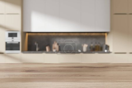 Téléchargez les photos : Table en bois vide sur fond d'intérieur de cuisine maison blanche et beige, espace de cuisson flou avec armoire et ustensiles de cuisine. Maquette de l'espace de copie pour l'affichage du produit. rendu 3D - en image libre de droit