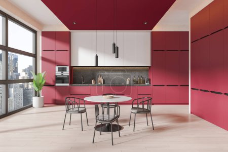 Téléchargez les photos : Intérieur d'une cuisine élégante avec murs rouges, sol en bois, placards blancs, armoires rouges et table à manger ronde avec chaises. Rendu 3d - en image libre de droit