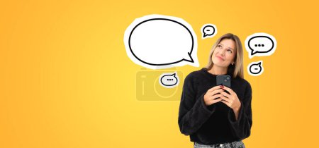 Photo for Beautiful young European woman standing with smartphone over yellow copy space background with speech bubbles. Concept of communication - Royalty Free Image