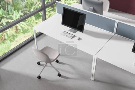 Foto de Vista superior del interior del espacio de trabajo con monitores de PC en el escritorio, sillas en el suelo de hormigón gris. Elegante oficina de trabajo con muebles minimalistas y ventana panorámica en los trópicos. Renderizado 3D - Imagen libre de derechos