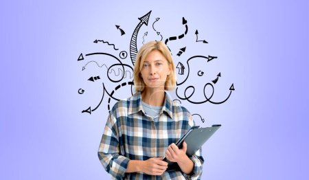 Photo for Portrait of beautiful young woman student standing with clipboard over purple background with arrows. Concept of planning and bright ideas - Royalty Free Image