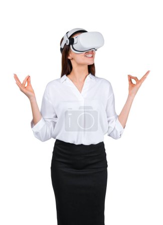 Téléchargez les photos : Femme d'affaires méditant dans des lunettes vr, isolée sur fond blanc. Femme debout avec des doigts de lotus, se détendre après une dure journée de travail. Concept de froid en métaverse - en image libre de droit