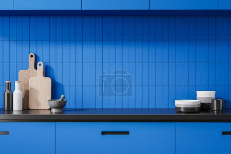 Téléchargez les photos : Élégant intérieur de cuisine bleu avec vaisselle et ustensiles de cuisine sur le comptoir, planche à découper, épices et assiettes. Gros plan de la zone de cuisson colorée avec mur de tuiles. rendu 3D - en image libre de droit