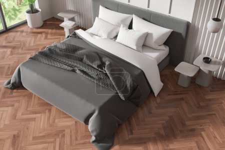 Foto de Un interior de dormitorio moderno con una cama sin hacer, muebles y una gran ventana, representación realista en un piso de arenque, concepto de diseño del hogar. Renderizado 3D - Imagen libre de derechos
