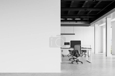 Foto de Elegante interior de oficina con ordenadores PC en escritorios y sillones, suelo de hormigón. Espacio minimalista de coworking con ventana panorámica sobre rascacielos. Mockup pared vacía. Renderizado 3D - Imagen libre de derechos