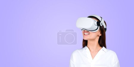 Foto de Mujer europea joven con auriculares VR AR y surfeando realidad inmersiva ciberespacio metaverso. Dispositivo portátil cibernético de alta tecnología. Copiar espacio de fondo. Colocación y experiencia del producto y solución de juego - Imagen libre de derechos