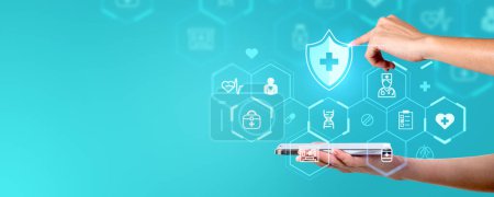 Téléchargez les photos : Une main interagissant avec des icônes médicales projetées sur un smartphone sur un fond bleu, symbolisant la technologie des soins de santé - en image libre de droit