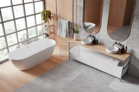 Photo for A spacious, modern bathroom interior with a freestanding bathtub, double sink vanity unit, mirrors, and a large window with a garden view. 3D Rendering - Royalty Free Image