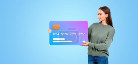 Téléchargez les photos : Une femme présentant une carte de crédit géante, avec un style graphique plat, sur fond bleu, concept de banque et de finance - en image libre de droit