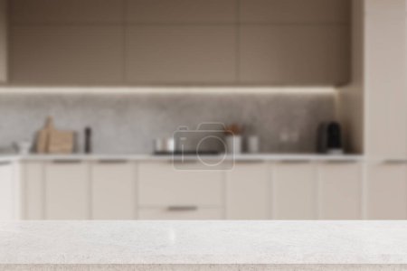 Foto de Mesa de presentación producto blanco de pie en el interior borroso de la elegante cocina con paredes grises, armarios beige y armarios con cocina incorporada. renderizado 3d - Imagen libre de derechos