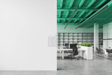Foto de Interior de la elegante oficina de espacio abierto con paredes blancas, suelo de hormigón, techo verde, fila de escritorios de computadora blancos, estanterías grises y pared de espacio de copia a la izquierda. renderizado 3d - Imagen libre de derechos