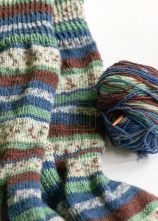 Photo for Woolen knitted socks, knitting yarn and knitting needles, knitted fashion, needlework clothing, winter hobby, needlework concept. Homemade crochet, needlework - Royalty Free Image