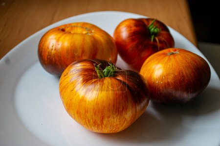 Foto de Tomates coloridos, jugosos y saludables en un plato, una nutrición sabrosa y saludable, adecuada para vegetarianos - Imagen libre de derechos