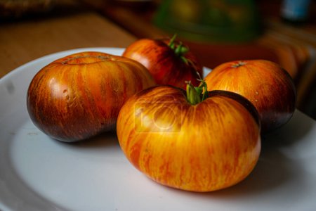 Foto de Tomates coloridos, jugosos y saludables en un plato, una nutrición sabrosa y saludable, adecuada para vegetarianos - Imagen libre de derechos