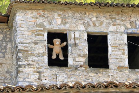 Téléchargez les photos : Une tradition albanaise - jouets en peluche suspendus dans une fenêtre d'une maison pour apporter le bonheur, Albanie - en image libre de droit