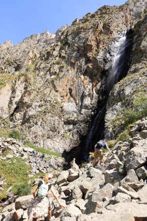 Foto de 19 de agosto de 2023 - Parque Nacional Ala Archa, Kirguistán en Asia Central: la gente disfruta de una cascada en el Parque Nacional Ala Archa en verano - Imagen libre de derechos