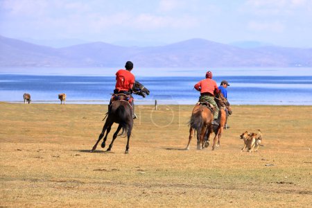 Téléchargez les photos : 24 août 2023 - Lac Song kol au Kirghizistan : Les locaux jouent au hamburu (ulak tartysh), jeu de chevaux traditionnel, avec mannequin en cuir au lieu d'une carcasse de chèvre - en image libre de droit