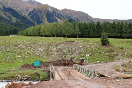 Téléchargez les photos : 28 août 2023 - Jeti Oguz, région d'Issyk-Kul au Kirghizistan : les locaux montent à cheval dans les montagnes par une journée nuageuse - en image libre de droit