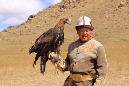 Foto de 27 de agosto de 2023 - Bokonbayevo, provincia de Issyk Kul, Kirguistán: un cazador de águilas kirguís con su águila - Imagen libre de derechos