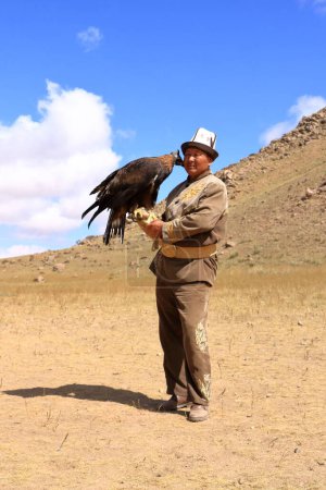Foto de 27 de agosto de 2023 - Bokonbayevo, provincia de Issyk Kul, Kirguistán: un cazador de águilas kirguís con su águila - Imagen libre de derechos