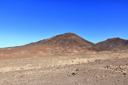 Schotterpiste, staubige Straße mit hohen Vulkanbergen im Hintergrund. Jandia, Morro Jable, Fuerteventura, Kanarische Inseln in Spanien