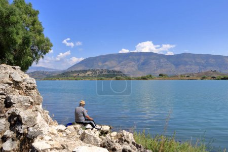 September 17 2023 - Butrint in Albania: An albanian fisherman on Butrint lake salt lagoon, view from Butrint National Park, the famous UNESCO World Heritage Site