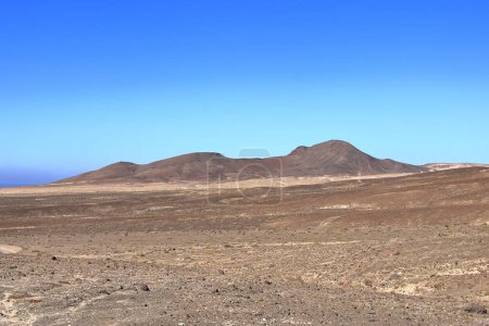 Schotterpiste, staubige Straße mit hohen Vulkanbergen im Hintergrund. Jandia, Morro Jable, Fuerteventura, Kanarische Inseln in Spanien