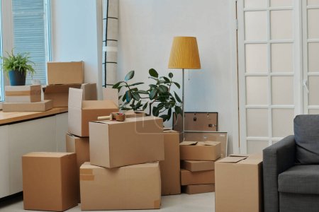Photo for Horizontal image of modern room with packed cardboard boxes preparing for moving - Royalty Free Image