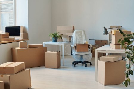 Foto de Imagen horizontal de gran oficina ligera con muebles y cajas de cartón embaladas - Imagen libre de derechos
