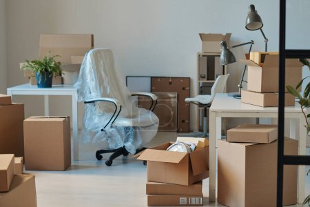 Téléchargez les photos : Image horizontale de grand bureau lumineux avec de nouveaux meubles et des boîtes en carton déballées - en image libre de droit