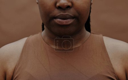 Photo for Close-up of black young woman in tank top isolated on brown background - Royalty Free Image
