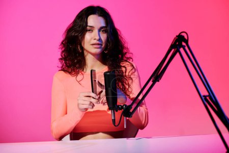 Stylische junge kaukasische Influencerin sitzt am Schreibtisch im Studio und nimmt Sounds auf, die mit Haarkamm für ASMR-Video gemacht wurden