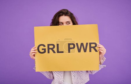 Photo for Portrait of young girl standing behind Girl Power poster against purple background and supporting women rights - Royalty Free Image