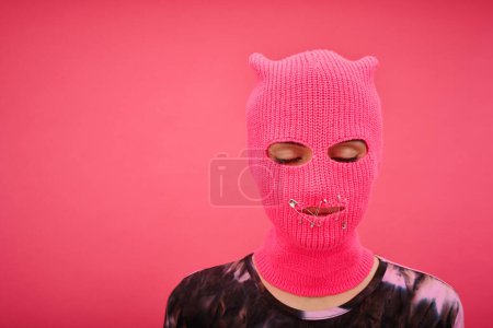 Photo for Portrait of yung girl in pink balaclava with closed mouth and eyes having no rights isolated on p - Royalty Free Image