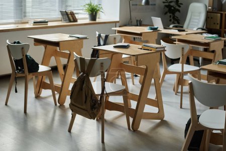 Téléchargez les photos : Salle de classe moderne vide avec des bureaux en bois pour les étudiants - en image libre de droit