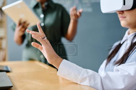 Photo for Student using VR glasses at lesson with teacher explaining information in background - Royalty Free Image