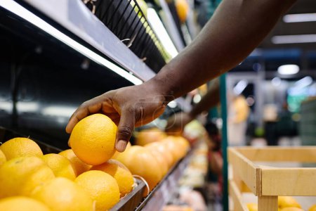 Photo for Close-up of customer buying fresh oranges in supermarket - Royalty Free Image