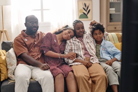 Photo for Happy Black family resting on couch at home and watching tv show - Royalty Free Image