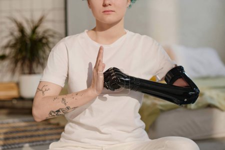 Foto de Imagen recortada de chica con brazo protésico cibernético haciendo puño y gesto de palma - Imagen libre de derechos