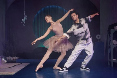 Téléchargez les photos : Plan large de ballerine démontrant une figure de ballet, jeune homme élégant répétant après elle - en image libre de droit