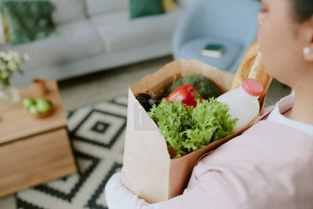 Close up photo of bag content held by nurse, paper bag full of healthy food