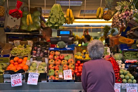 Photo for Old lady standing at a fruit stand at the market of Cadiz. The woman is unknown - Royalty Free Image