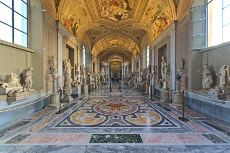 Foto de Dentro de los museos Vaticanos en uno de los largos pasillos con pocos visitantes - Imagen libre de derechos